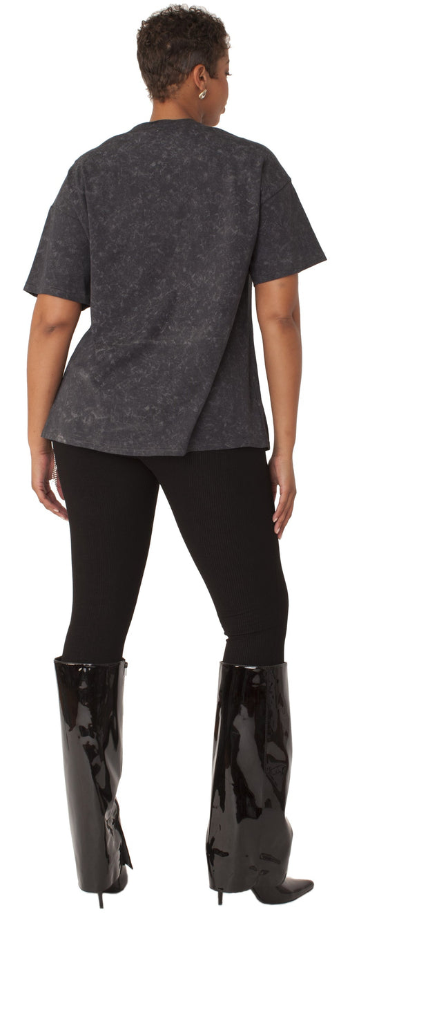 Person wearing a dark gray shirt and black pants with black boots on a white background.