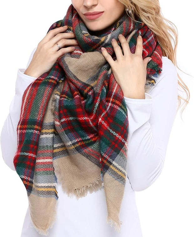 A woman wearing a white top is seen from the shoulders up, draped with a large, multicolored plaid scarf with fringe.